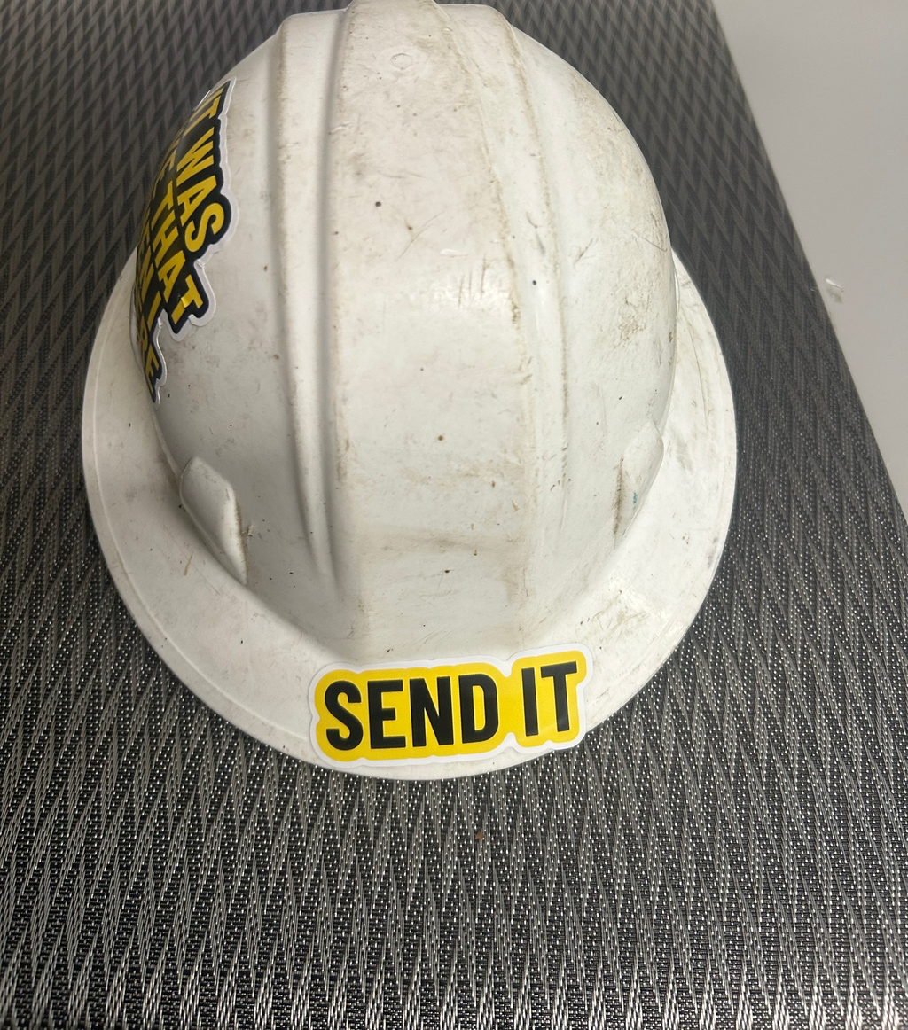 Send It decal on the brim of a real, dirty white hard hat